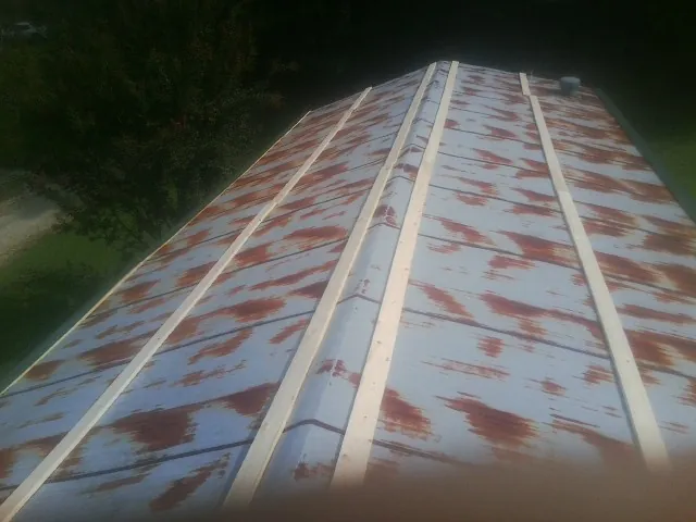Rusted metal roof panels with new wood purlins before replacement — Storm Damage Roof Repair in Badger by Roofing Brothers